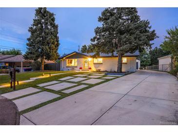 Charming home featuring a modern driveway design and beautiful curb appeal with manicured lawn and mature trees at 1260 Hoyt St, Lakewood, CO 80215