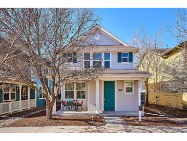 Charming two-story home boasts a covered porch, freshly landscaped yard, and an inviting teal front door at 2362 Xanthia Way, Denver, CO 80238