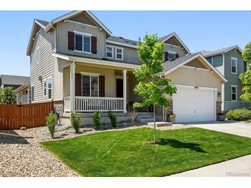 Charming two-story home with a well-manicured lawn, inviting front porch, and attached two-car garage at 16975 Melody Dr, Broomfield, CO 80023