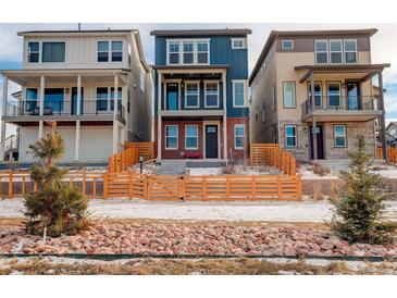 Charming two-story home with a blue facade, brick accents, and a lovely wooden fence at 11063 Shining Star Cir, Parker, CO 80134