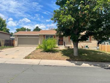 Ranch-style home with attached garage and mature landscaping at 2597 S Dillon St, Aurora, CO 80014