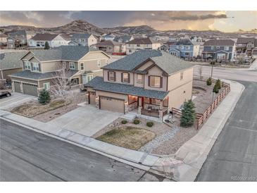 Beautiful two-story home with a spacious driveway and manicured front yard landscaping at 7310 Blue Water Dr, Castle Rock, CO 80108