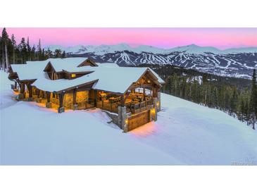 Stunning mountain home with snow-covered roof, stone accents and view of ski runs at 250 Sallie Barber Rd, Breckenridge, CO 80424