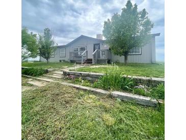 Charming single-story home featuring a front deck, well-maintained lawn, and inviting curb appeal at 47904 Dartmouth Ave, Bennett, CO 80102