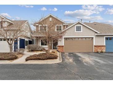 Charming townhome exterior featuring a two-car garage and well-maintained landscaping in a suburban neighborhood at 9118 W 50Th Ln # 5, Arvada, CO 80002