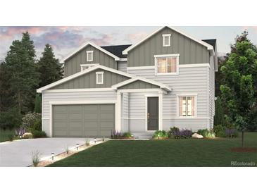 Charming two-story home with a two-car garage, a well-manicured lawn, and tasteful landscaping at 4325 Gozzer Ranch Dr, Elizabeth, CO 80107