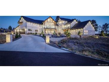 Beautiful two-story home featuring a circular driveway, stone accents, manicured landscaping, and a welcoming entrance at 13176 Frannys Way, Parker, CO 80138