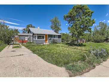 Charming home with a well-maintained lawn and a striking orange front door at 1271 Uinta St, Denver, CO 80220