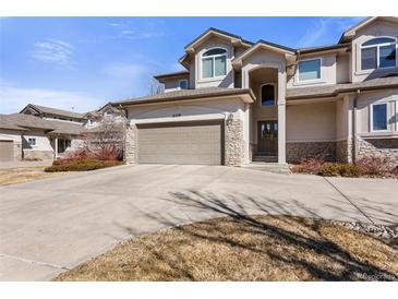 Charming home featuring a stone facade, attached garage and mature landscaping at 8559 W 93Rd W Ct, Broomfield, CO 80021