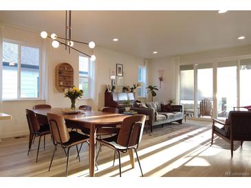 Open concept living and dining area with large windows, stylish furnishings, and abundant light at 5211 Routt Ct, Arvada, CO 80002
