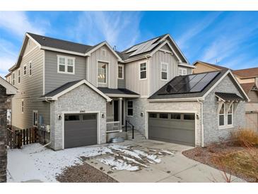 Two-story house with gray siding, stone accents, and solar panels at 10993 Ledges Rd, Parker, CO 80134