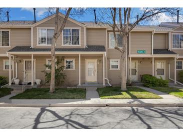 Charming townhouse showcasing a well-maintained front yard and covered entrance at 1818 S Quebec Way # 3-4, Denver, CO 80231