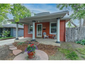 Charming home featuring a cozy front porch with decorative columns and a colorful garden display at 4841 Alcott St, Denver, CO 80221