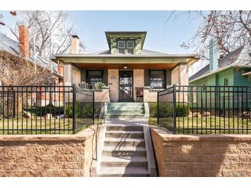 Charming bungalow with a brick facade, black iron fence, and inviting front porch, ideal for relaxing in the neighborhood at 438 S Emerson St, Denver, CO 80209