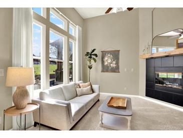 Bright living room with large windows, fireplace, and comfortable seating at 3720 Pecos Trl, Castle Rock, CO 80109