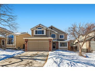 Two-story house with attached garage, brick accents, and snow-covered landscaping at 209 S Pembrook St, Castle Rock, CO 80104