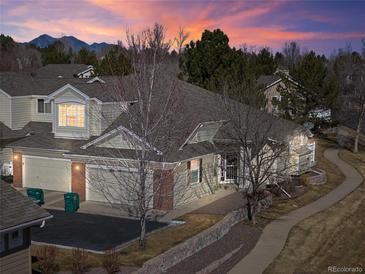 Charming home with a landscaped yard, two-car garage, mountain views at sunset, and sidewalk access at 13535 W 62Nd Ln, Arvada, CO 80004