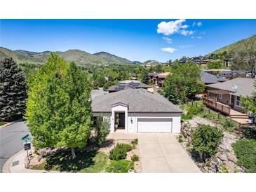 Charming single-story home with mature trees, lush landscaping, and an attached two-car garage at 330 Ptarmigan St, Golden, CO 80403