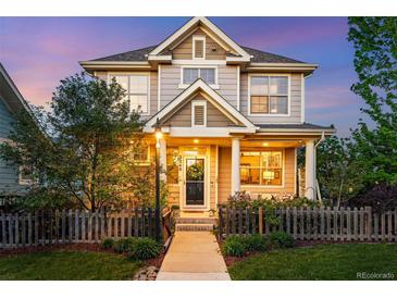 Charming two-story home boasts a welcoming front porch and manicured front yard at 3240 Spruce St, Denver, CO 80238