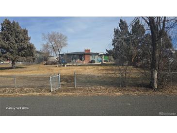 Charming single-story home featuring a spacious front yard, fenced perimeter, and mature trees at 15600 E 33Rd Pl, Aurora, CO 80011