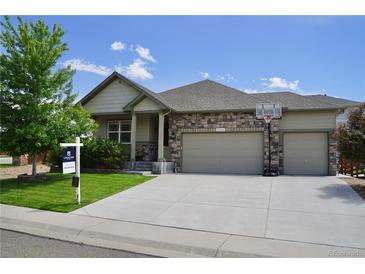 Charming single-Gathering home boasts a stone and vinyl facade, two-car garage, and well-maintained front yard at 22466 E Layton Cir, Aurora, CO 80015