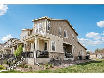 Two-story home with covered porch, neutral siding and manicured landscaping at 5388 Routt St # B, Arvada, CO 80002