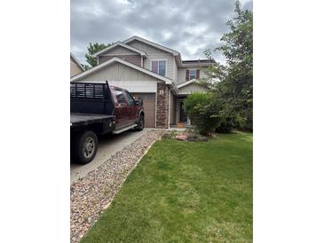 Charming two-story home with a well-maintained lawn, beautiful rock details, and a convenient attached garage at 13664 Linden Ct, Thornton, CO 80602