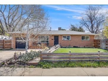 Charming brick home with a well-manicured front yard and a quaint wooden fence at 3200 Eastman Ave, Boulder, CO 80305
