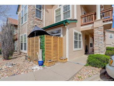 Charming condo featuring stone accents, wood siding, and a cozy, fenced patio area with privacy screen at 3993 S Dillon Way # 104, Aurora, CO 80014
