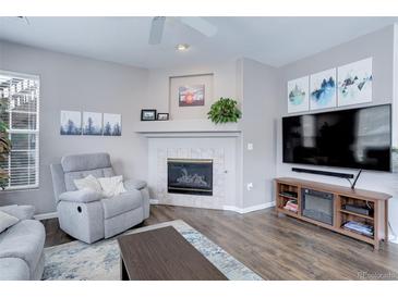 Comfortable living room with a decorative fireplace, modern TV setup, and a cozy gray recliner at 3993 S Dillon Way # 104, Aurora, CO 80014