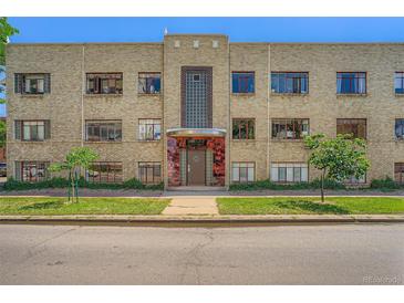 A three-story residential brick building with a distinctive art deco entrance and manicured lawn at 1000 E 8Th Ave # 4, Denver, CO 80218