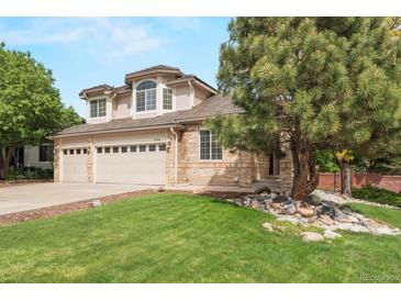Lovely two-story home featuring a brick and siding facade and a three-car garage with beautifully maintained landscaping at 9432 La Quinta Way, Lone Tree, CO 80124