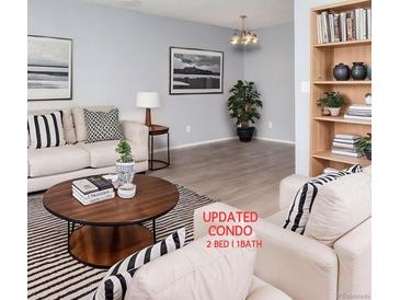 Bright living room featuring hardwood floors, modern furniture and decor, and a built-in bookshelf at 10722 E Exposition Ave # 314, Aurora, CO 80012