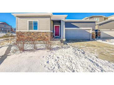 House exterior featuring a two-car garage and a red front door at 12785 Horton Ct, Parker, CO 80134