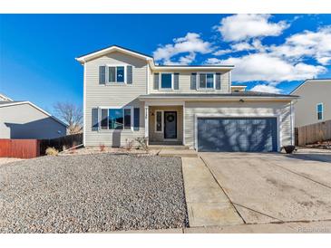 Charming two-story home featuring a gray two car garage, and low maintenance landscaping at 7132 Eagle Rock Dr, Littleton, CO 80125