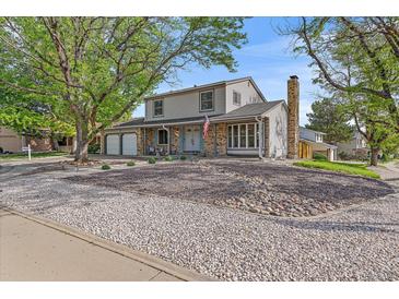 Charming two-story home with a well-maintained lawn, mature trees, and a two-car garage at 18263 E Mansfield Ave, Aurora, CO 80013