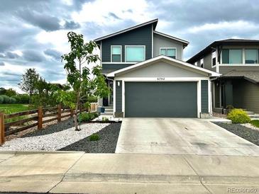View of the home's front exterior showcasing a modern design, large garage door, and well-kept landscaping at 6792 Canosa St, Denver, CO 80221