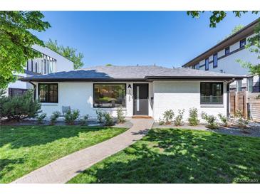 Charming painted brick home with well-manicured lawn and walkway at 1065 S Monroe St, Denver, CO 80209