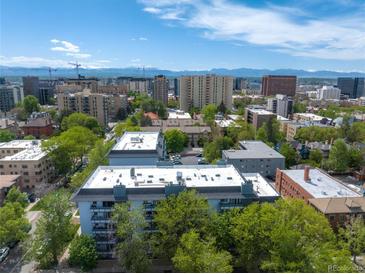 Scenic aerial view of the city buildings with mountain views, a perfect urban oasis at 555 E 10Th Ave # 111, Denver, CO 80203
