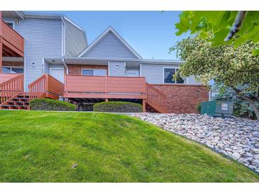 Inviting townhouse featuring a front porch, brick accents, and a well-maintained lawn at 4135 E 119Th Pl # A, Thornton, CO 80233