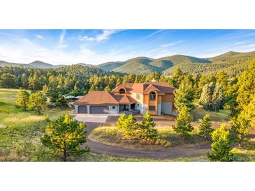 Mountain view home with large yard and three-car garage at 22196 Boar Head Rd, Indian Hills, CO 80454