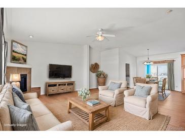 Inviting living room with comfortable seating, fireplace, and entertainment center at 51 W 6Th Pl, Byers, CO 80103