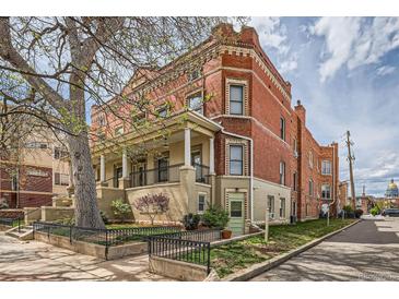 Charming brick apartment building with a covered front porch and mature landscaping in a desirable neighborhood at 1425 N Washington St # 104, Denver, CO 80203