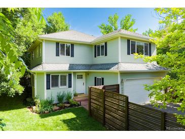 Charming two-story home featuring lush landscaping, a fenced yard, and an attached garage at 1409 Quince Ave, Boulder, CO 80304