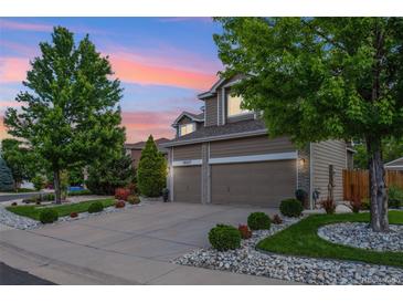 Beautiful two-story home with a two-car garage, well-manicured lawn, and lush landscaping at 18027 E Ida Dr, Centennial, CO 80015