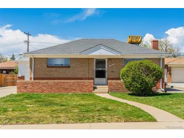 Charming brick home featuring a well-maintained lawn and inviting walkway at 7651 Shoshone St, Denver, CO 80221
