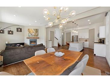 Bright open-concept living space featuring a cozy fireplace and modern lighting fixtures at 4035 Fenton Ct, Wheat Ridge, CO 80212