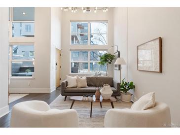 Bright living room features high ceilings, large windows, modern decor, and hardwood floors at 2506 16Th St, Denver, CO 80211
