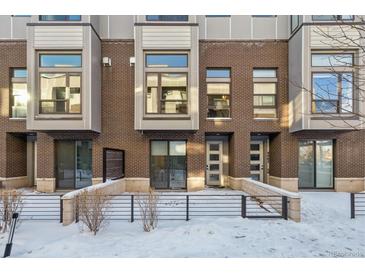 Modern brick townhome with private patio and snow-covered front yard at 4060 W 16Th Ave, Denver, CO 80204