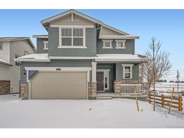 Two-story home with gray siding, neutral garage door, and stone accents at 241 Paloma Way, Elizabeth, CO 80107